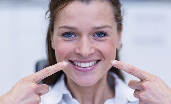 Woman smiling after metal-free dental restoration treatment