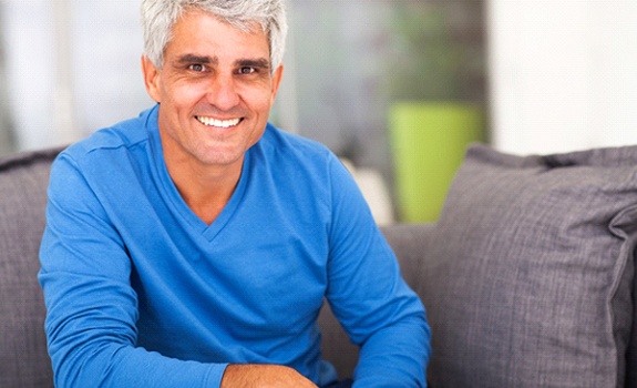 Older man smiling while wearing a blue sweater