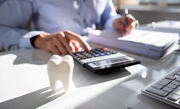 patient calculating cost of tooth extraction in Dallas