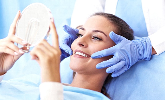 Woman with brown hair getting an Invisalign consultation from her dentist