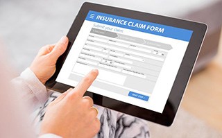Person filling out insurance claim form on tablet