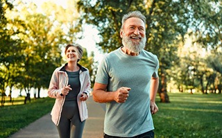Happy, healthy older couple jogging outdoors