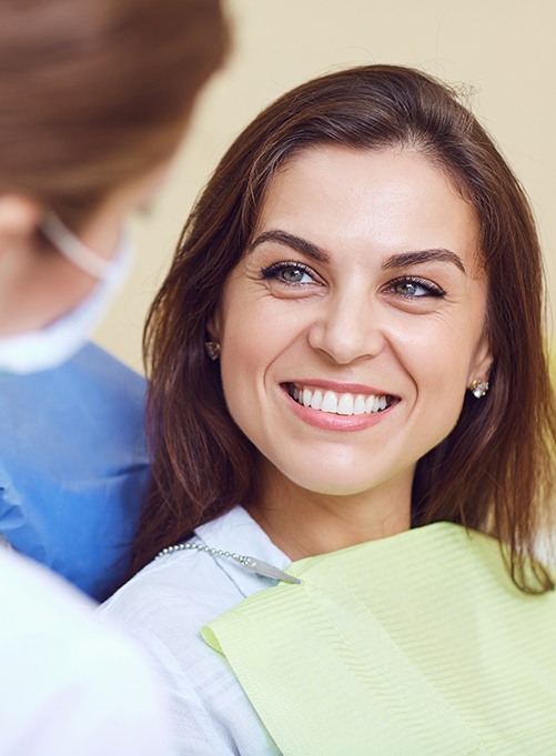 A smiling woman looking at her dentist