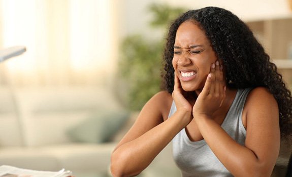 Woman in pain, touching the sides of her face