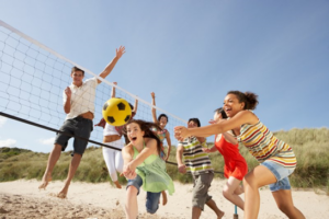 Group of teenagers playing beach volleyball on the sand